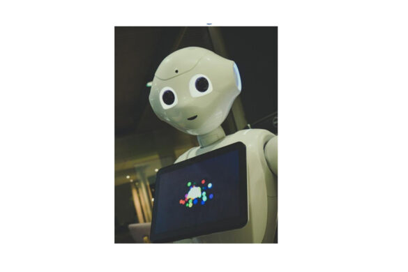 An image of a white robot holding a black tablet